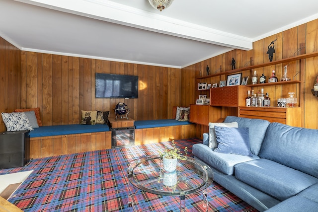 living room with beam ceiling, wooden walls, and ornamental molding