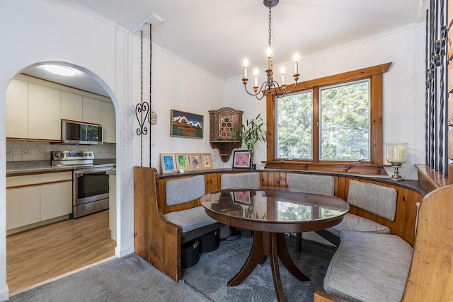 carpeted dining room with ornamental molding and a notable chandelier