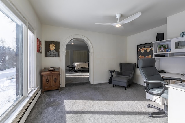 office area with dark carpet, a baseboard radiator, and ceiling fan