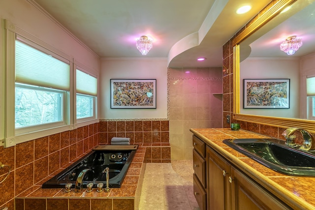 bathroom featuring ornamental molding, a bathtub, tile walls, and vanity