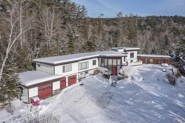 view of front of property featuring a garage and a sunroom