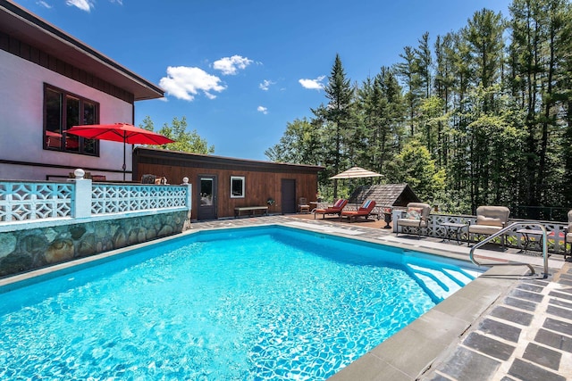 view of swimming pool featuring an outbuilding and a patio area