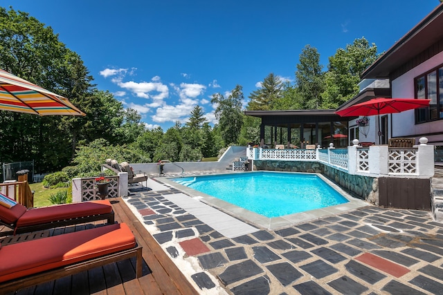 view of pool with a sunroom and a patio