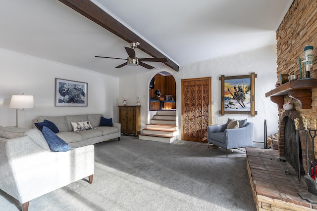 living room with ceiling fan, a fireplace, carpet floors, and vaulted ceiling with beams