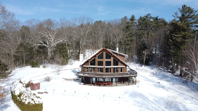 snow covered rear of property featuring a wooden deck