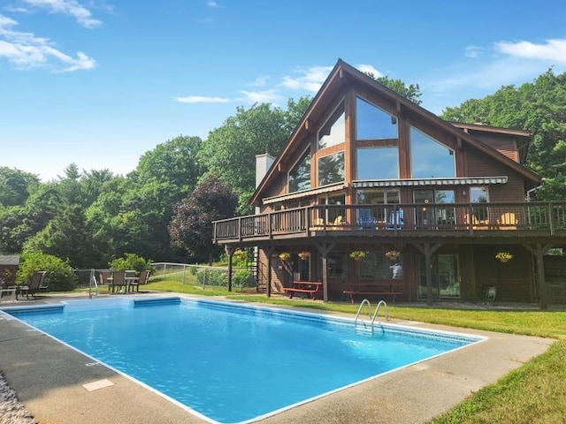 view of pool with a deck and a lawn