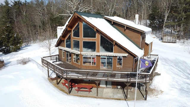 snow covered house with a deck