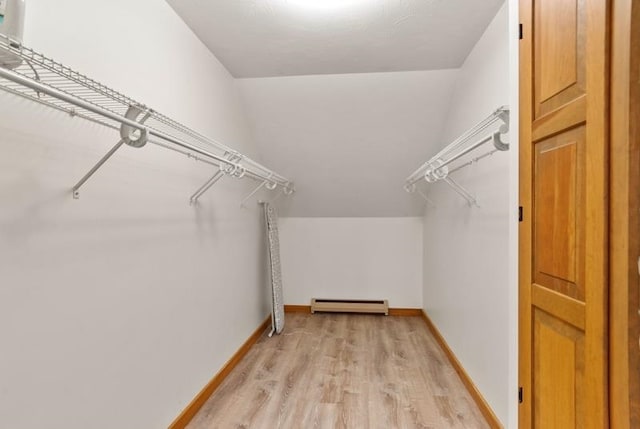 walk in closet featuring a baseboard heating unit and light hardwood / wood-style floors