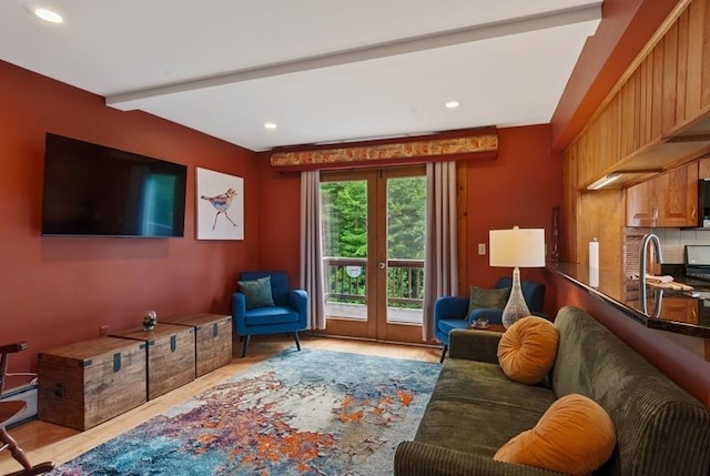 living room with french doors, a baseboard radiator, beam ceiling, and sink