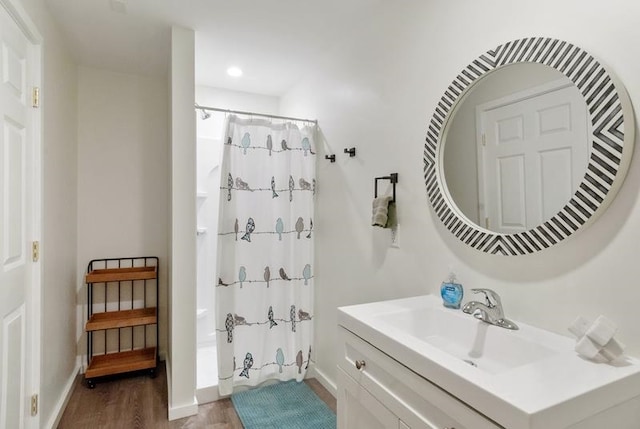 bathroom featuring vanity, wood-type flooring, and walk in shower