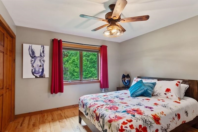 bedroom featuring light hardwood / wood-style floors, a closet, and ceiling fan