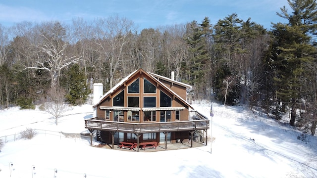 snow covered house with a wooden deck