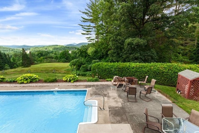 view of pool with a patio and a mountain view