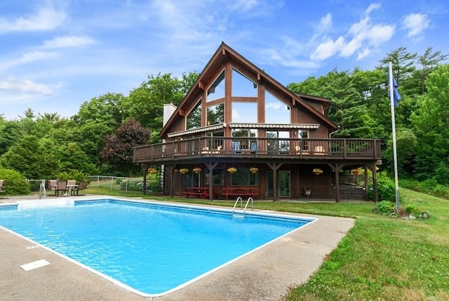 view of swimming pool with a deck and a lawn