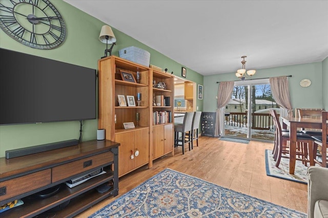 living room with an inviting chandelier and light hardwood / wood-style flooring