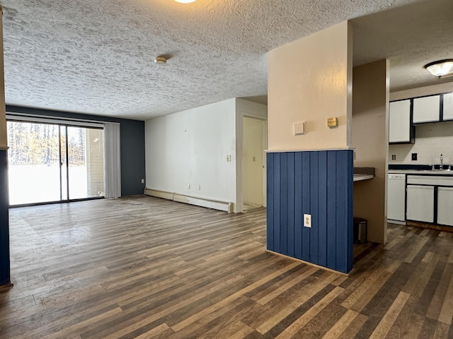 unfurnished living room with white cabinetry, dark wood-type flooring, sink, and a baseboard heating unit