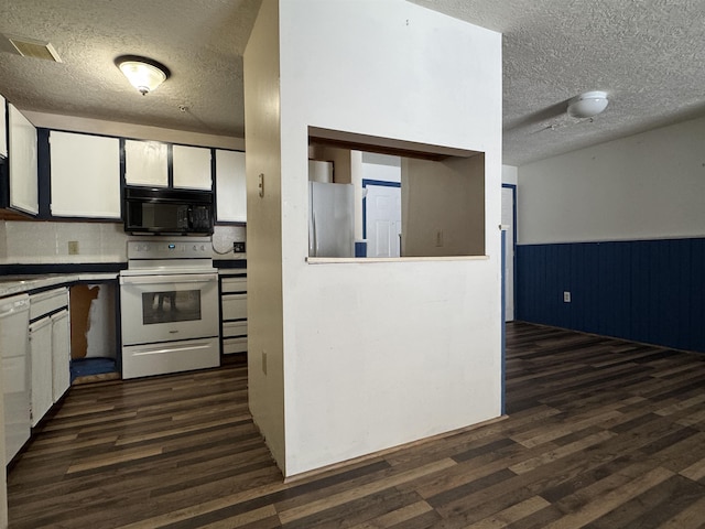 kitchen with white electric range, dark wood-type flooring, white cabinets, and stainless steel fridge