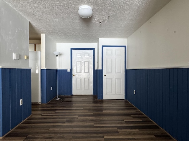 empty room featuring a textured ceiling and dark hardwood / wood-style flooring