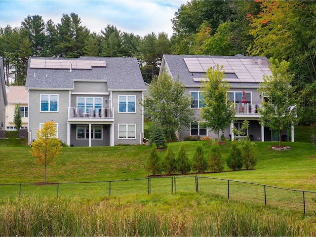 exterior space featuring a yard, solar panels, and a balcony