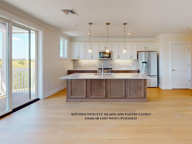 1 Longview Dr Unit 207, Atkinson, NH 03811 - kitchen with stainless steel appliances, an island with sink, hanging light fixtures, and white cabinets