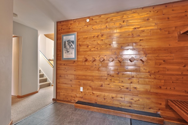 interior space featuring carpet flooring and wooden walls