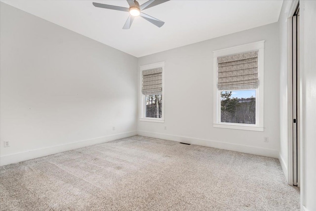 empty room featuring baseboards, a ceiling fan, a healthy amount of sunlight, and carpet flooring