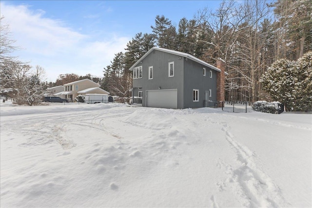 view of snowy exterior with a garage