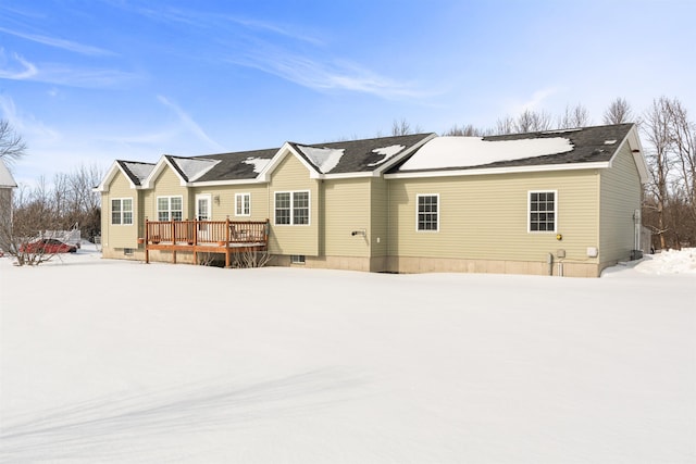 snow covered house with a deck