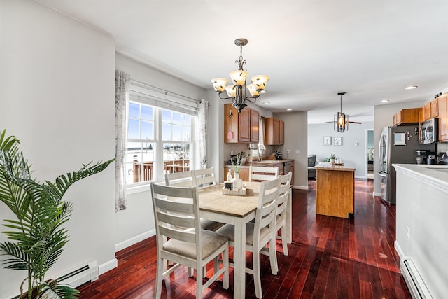 dining room with baseboards, dark wood-type flooring, baseboard heating, a chandelier, and recessed lighting