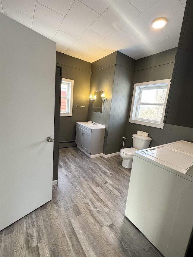 bathroom featuring hardwood / wood-style flooring, vanity, toilet, and a wealth of natural light