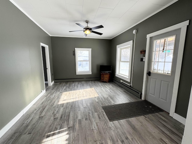 entrance foyer featuring crown molding, wood-type flooring, ceiling fan, and baseboard heating