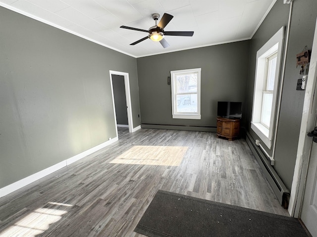 unfurnished living room with hardwood / wood-style flooring, a baseboard radiator, ceiling fan, and crown molding