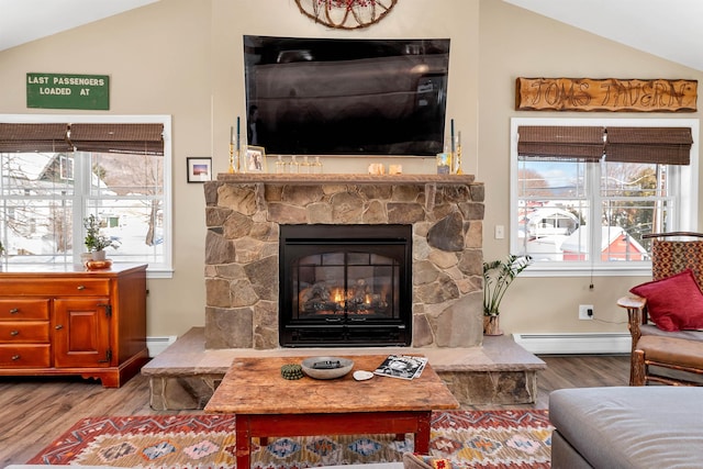 living area with hardwood / wood-style flooring, lofted ceiling, a fireplace, and a baseboard heating unit