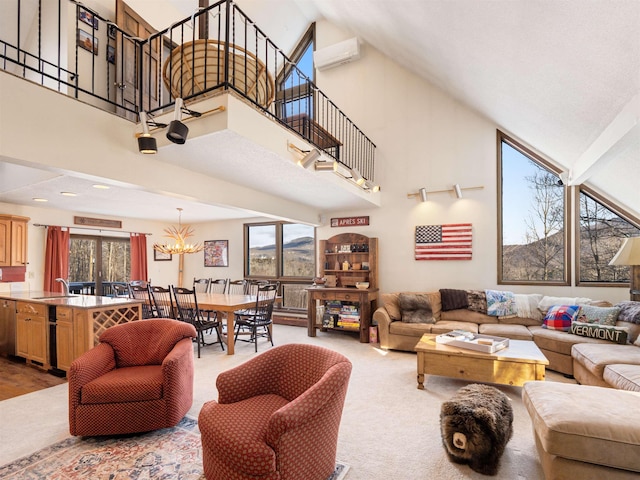 living room featuring a towering ceiling, sink, carpet floors, and a notable chandelier