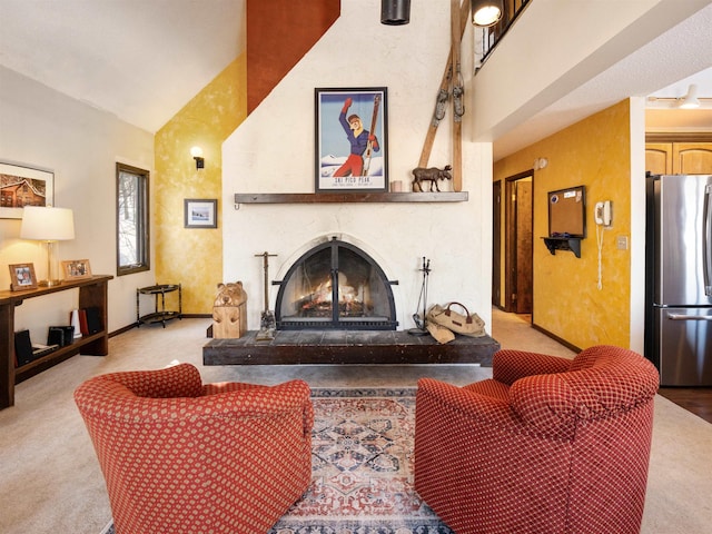 carpeted living room featuring a large fireplace and high vaulted ceiling