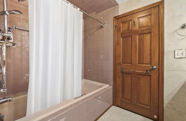 bathroom with shower / bath combo and tile walls