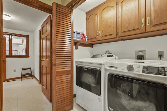 washroom with cabinets, light tile patterned floors, and independent washer and dryer