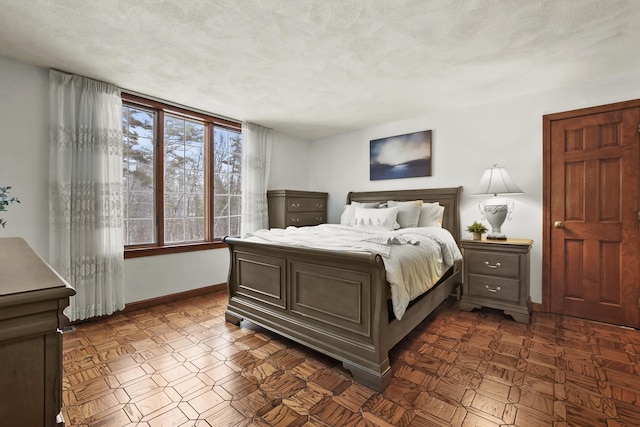 bedroom with dark parquet flooring and a textured ceiling