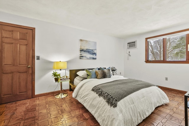 bedroom featuring parquet floors and an AC wall unit