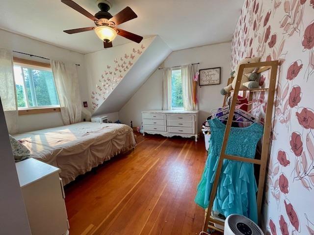 bedroom with ceiling fan, dark hardwood / wood-style flooring, and vaulted ceiling