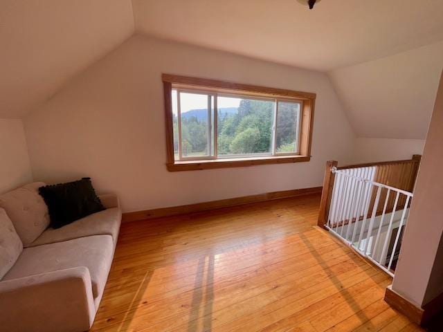 additional living space with lofted ceiling and light hardwood / wood-style flooring