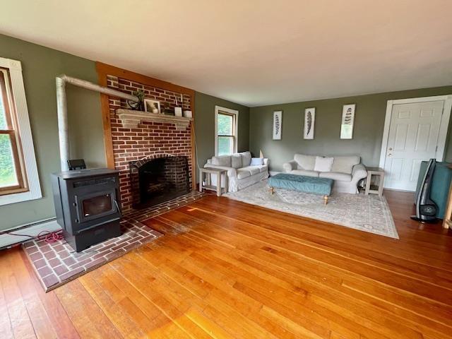 living room with a wood stove and hardwood / wood-style floors