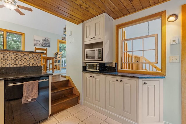 kitchen featuring tasteful backsplash, white cabinetry, dishwasher, light tile patterned floors, and wooden ceiling