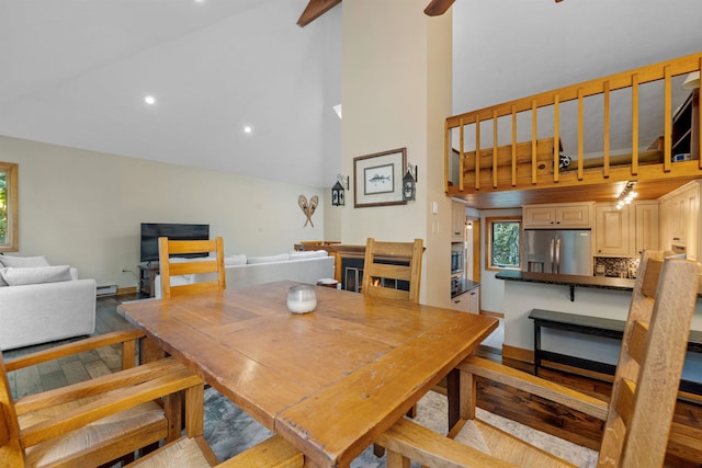 dining room featuring light wood-type flooring, high vaulted ceiling, and a wealth of natural light