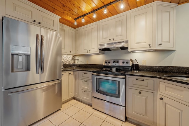 kitchen featuring white cabinets, appliances with stainless steel finishes, dark stone counters, and light tile patterned floors