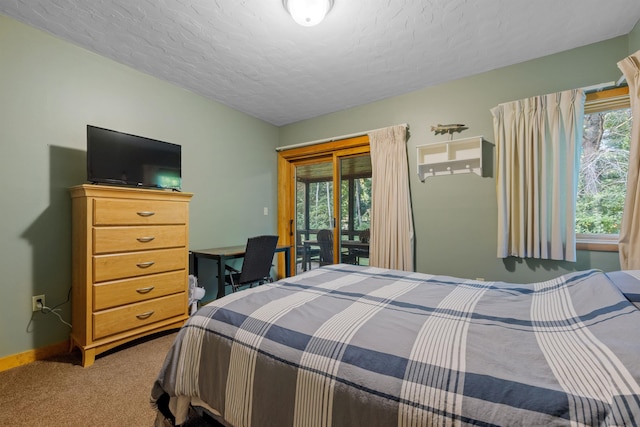 carpeted bedroom featuring access to outside and a textured ceiling