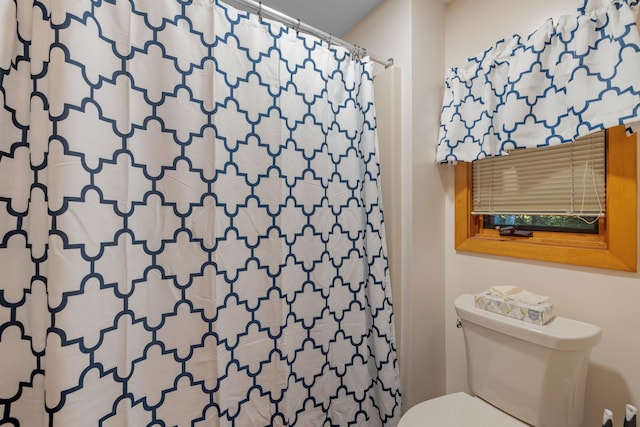 bathroom with toilet and a shower with shower curtain