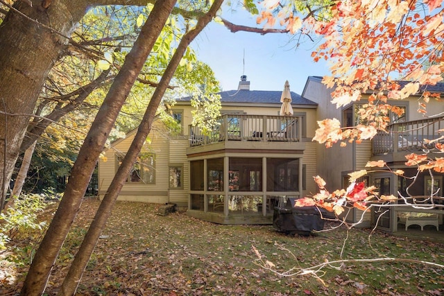 back of house with a balcony and a sunroom