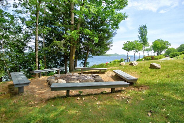 view of property's community with a water view and a lawn