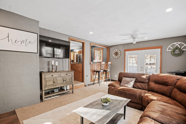 living room featuring french doors, light colored carpet, and ceiling fan